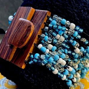 Beautiful beaded cuff bracelet in brown, white, blue, clear and wooden clasp